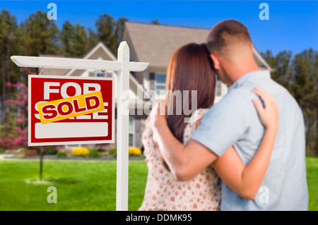 Für Immobilien Verkaufsschild und liebevolle militärische paar Blick auf schöne neue Haus verkauft. Stockfoto