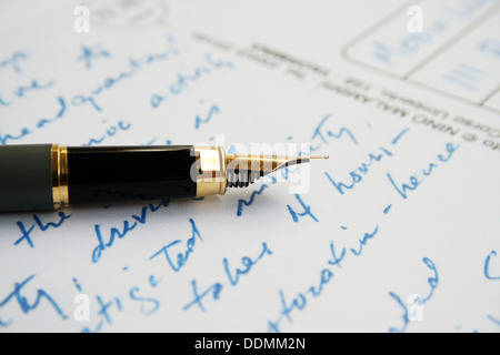 Buchstaben auf weißem Papier mit Stift Stockfoto