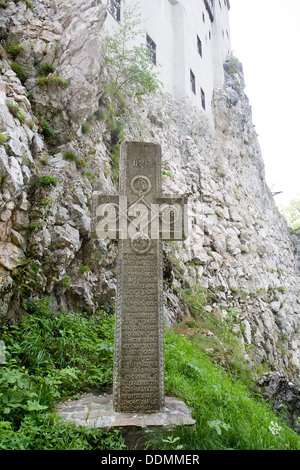 altes Steinkreuz in der Nähe der Wand des mittelalterlichen Schloss Bran, Walachei, Rumänien Stockfoto