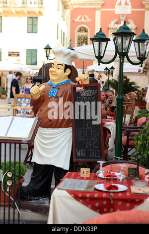 Restaurant in Korfu-Stadt in Griechenland mit der Panagia Spileotissa Kirche im Hintergrund Stockfoto