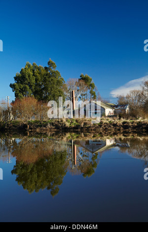 Alte Käserei Henley, spiegelt sich in Taieri River, Taieri Plains, in der Nähe von Dunedin, Otago, Südinsel, Neuseeland Stockfoto