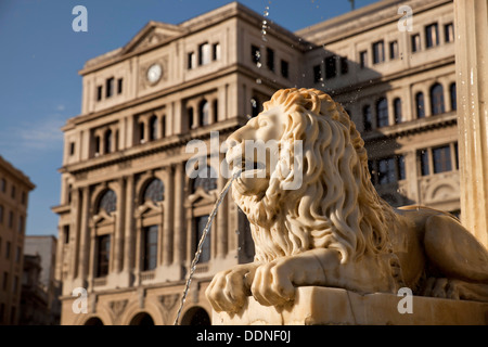 Marmor Löwe aus dem Brunnen Fuente de Los Leones und Havanna-Börse / Lonja del Comercio Gebäude am Plaza de San Francis Stockfoto