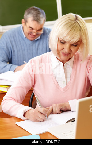 Porträt von Reife Frauen machen Notizen in Copybook mit senior woman auf Hintergrund Stockfoto