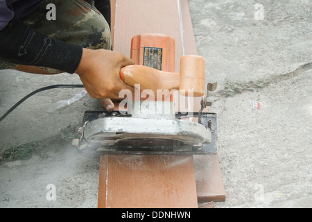 Arbeitnehmer nutzen eine Kreissäge, um Holz zu schneiden. Stockfoto