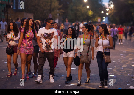 Glücklich Partygänger unterwegs zu Hause in den sterbenden Licht an einem Sommerabend in Notting Hill nach dem Karneval. Stockfoto