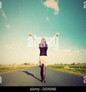 Glückliche Frau mit Händen stehend auf gerader Straße Sonne zugewandt. Zukunft / Freiheit / hoffe / Erfolgskonzept Stockfoto