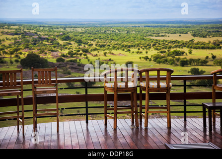 Safari in der Serengeti, Tansania, Afrika. Stühle auf der Terrasse einer Lodge mit Blick auf die Ebene Stockfoto