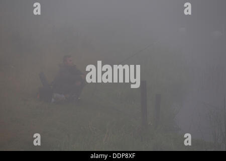 Northamptonshire, UK. 5. September 2013. Starker Nebel Verlegung in Nene Valley heute Morgen ein einsamer Süßwasser Fischer sitzt am Ufer des Flusses Nene während des Wartens auf den Nebel zu löschen. Bildnachweis: Keith J Smith. / Alamy Live News Stockfoto