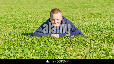 Schöne liegende Kind Rest im frischen Frühling Gras Stockfoto