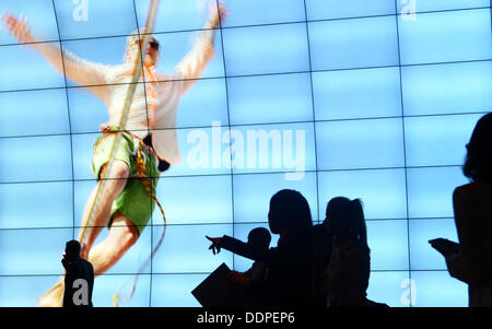 Berlin, Deutschland. 05. Sep, 2013. Die Menschen gehen vor einer Wand von Flachbild-Fernsehern im zweiten Pressetag auf der Berliner Radio Show in Berlin, Deutschland, 5. September 2013. Die IFA ist für die Öffentlichkeit vom 06 bis 11. September 2013 geöffnet. Foto: RAINER JENSEN/Dpa/Alamy Live-Nachrichten Stockfoto
