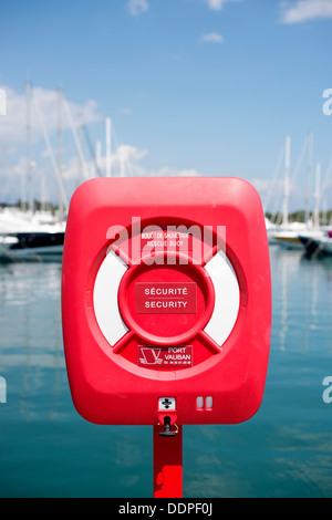 Einen roten Sperr-Rettungsring mit Luxus Yachten im Hintergrund am Yachthafen von Antibes, Côte d ' Azur, Frankreich Stockfoto