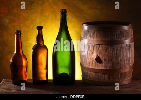 Holzfass mit Farben Flaschen auf einem dunklen gelben Hintergrund. Stockfoto