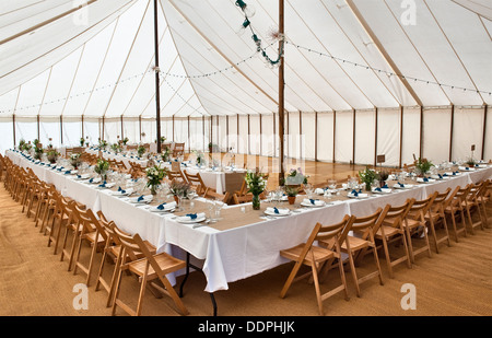 Interieur eines Festzeltes bei einer großen Hochzeit, mit Tischen, die für das Mittagessen bereit sind, Großbritannien Stockfoto