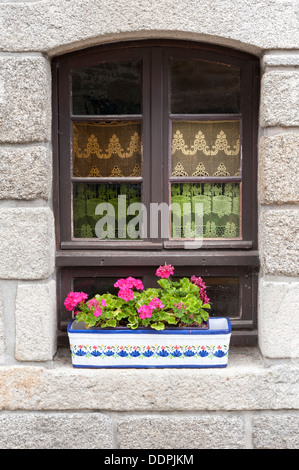 Hübsche Fenster in einem Gebäude in Brittany France mit Blumen im Blumenkasten Stockfoto