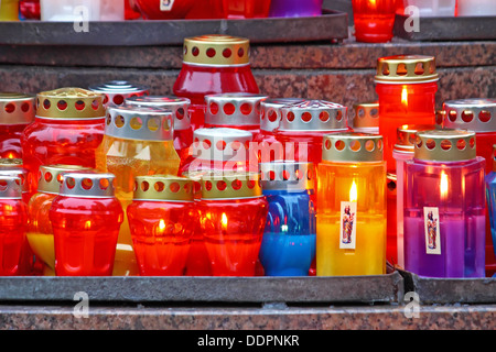 Viele beleuchtete votive Kerzen leuchtet auf einem Grab Stockfoto