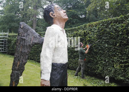 5. September 2013. Peak District, Derbyshire, UK. Presse Call: Chatsworth Gärtner, Rowan Tuffrey prägt die Buche Avenue neben Stephan Balkenhols bemalte Bronze "Engel" vor dem Start von Sotheby's Beyond Limits monumentale Skulptur Verkauf Ausstellung, Chatsworth House.  Über Grenzen hinaus umfasst mehr als 20 monumentale Skulpturen in ChatsworthÕs 105 Hektar großen Gärten von internationalen Künstlern wie Allen Jones, Jaume Plensa & Bosco Sodi. Über Grenzen hinaus läuft 9 Sept 27 Okt, 11:00-18:00 jeden Tag ohne Aufpreis über normalen Garten Eintritt Stockfoto