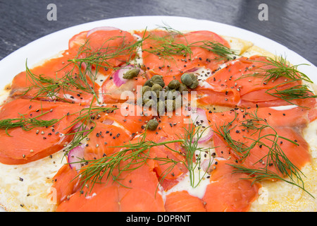 Geräucherter Lachs Pizza mit Kapern-Dill-Sahne-Käse-Zwiebel-Tomaten und rissige Paprika Closeup Stockfoto