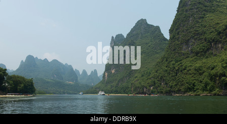 Ausflugsboote in den Li-Fluss mit Bergen im Hintergrund, Yangshuo, Guilin, Provinz Guangxi, China Stockfoto