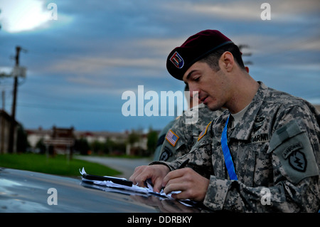 US Army Captain Matthew Shaw mit Stabskompanie, 4th Infantry Brigade Combat Team (Airborne), 25. Infanterie-Division, zeichnet die Zeiten der Renner, sie überqueren die Ziellinie nach Abschluss ein 17-Mile-Rennen zum Auftakt Sparta Woche hier ein Stockfoto