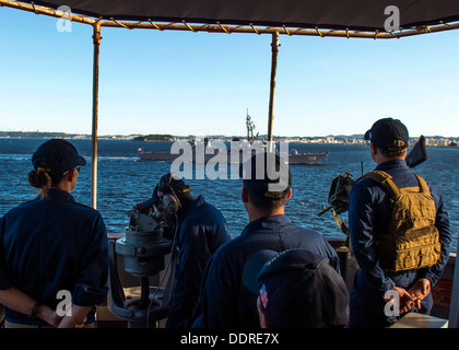 Segler beobachten Japan Maritime Self-Defense Force Zerstörer Takanami (DD-110) aus dem Brücke-Flügel der geführte Flugkörper Zerstörer USS Higgins (DDG-76) als das Schiff der Flotte, Yokosuka zieht. Higgins ist auf Patrouille in den USA sind der 7. US-Flotte Stockfoto