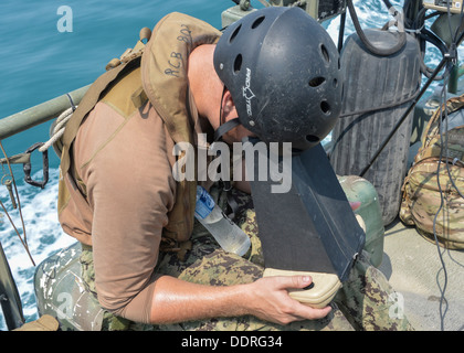 Elektroniker /-in arabischen Golf (3. September 2013) 3. Klasse Mitch Marema, zugewiesene Commander Task Group 56.7.4, Coastal Riverine Squadron 4, aus der Ferne steuert ein Puma AE unbemannten, an Bord ein Riverine Befehl Boot (RCB) auf See. RCBs prov Stockfoto