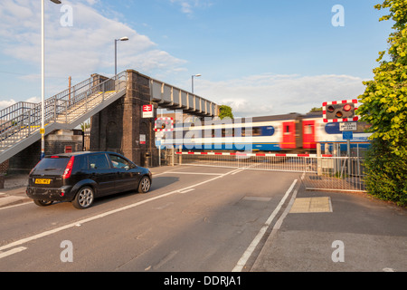 Auto Warten an einem Bahnübergang mit den Barrieren als Zug abgesenkt. Attenborough Bahnhof, Nottinghamshire, England, Großbritannien Stockfoto