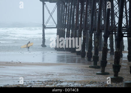 Surfer in der Nähe von Saltburn Pier bei starkem Regen. Saltburn von Meer, North Yorkshire, England, UK Stockfoto