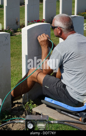 Stecher, die Wiederherstellung der Grabstein am Tyne Cot Friedhof der Commonwealth War Graves Commission für Erster Weltkrieg britische Soldaten Stockfoto