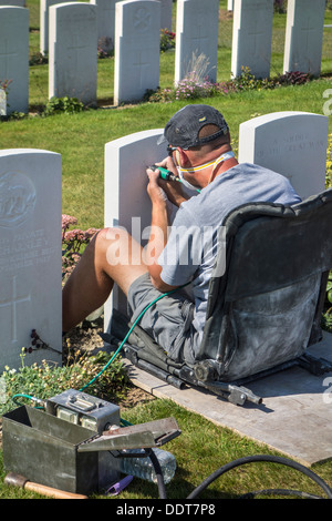 Stecher, die Wiederherstellung der Grabstein am Tyne Cot Friedhof der Commonwealth War Graves Commission für Erster Weltkrieg britische Soldaten Stockfoto