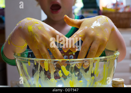 Kind spielt mit Mais-Mehl-Gemisch Stockfoto