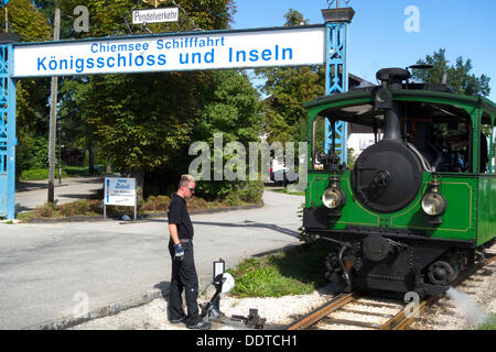 Chiemsee-Bahn Touristenzug und Mann vorbereiten der Gleise, Chiemsee Chiemgau, Upper Bavaria Germany wechseln Stockfoto
