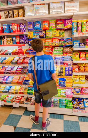 Ein 13 jähriger Junge Wahl einige Süßigkeiten in einem Ladengeschäft in Großbritannien Stockfoto