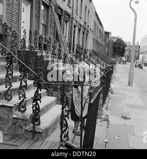 Frau fegt Eingangstreppe, London, 1960-1965. Künstler: John Gay Stockfoto