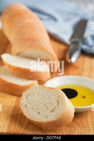 Baguette Baguette-Schliff an Bord der hölzernen Brot und Olivenöl. Selektiven Fokus Stockfoto