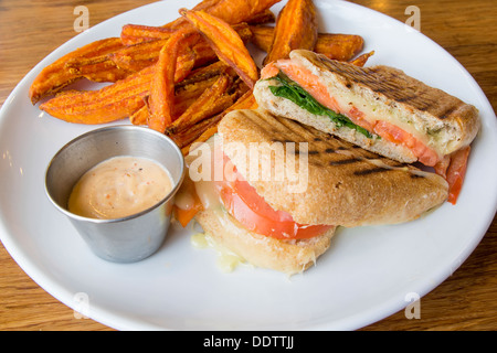 Geräucherter Lachs Spinat Tomate Mozzarella Käse Pesto Mayo und Süßkartoffel-Pommes frites Stockfoto