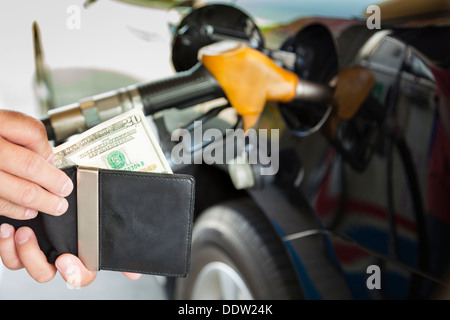 Mann Geldzählen mit Benzin tanken Auto an Tankstelle Stockfoto