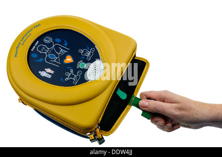 Frau entfernt die Pads aus einem automatischen Defibrillator Heartsine SAM350P Stockfoto