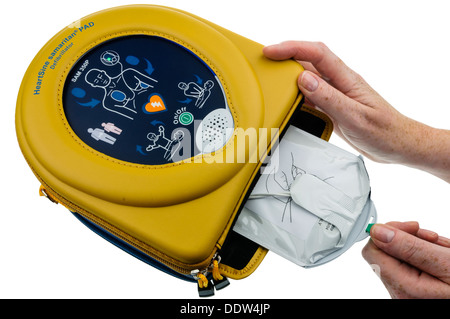 Frau entfernt die Pads aus einem automatischen Defibrillator Heartsine SAM350P Stockfoto