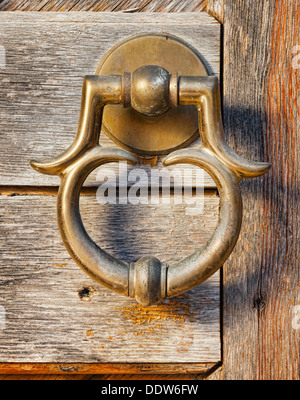 alte Messing-Türgriff am Holztor Stockfoto