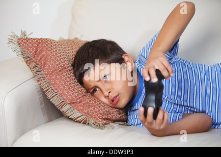 Kleiner Junge Computer-Spiel während des Relxing auf dem sofa Stockfoto