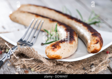 Deutsche Bratwurst mit Kräutern auf Vintage Holz-Hintergrund Stockfoto