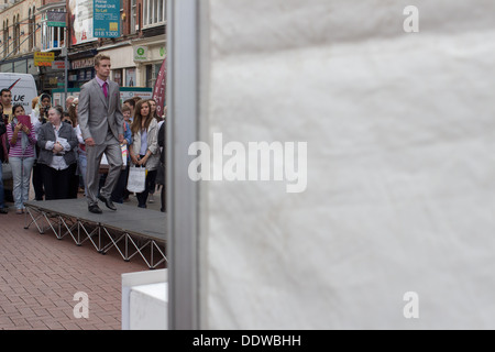 Männliches Model geht auf einem Outdoor-Runway auf einer Straße in Dublin vor Zuschauern während des Dublin Fashion Festival 2013 in Dublin, Irland. Stockfoto