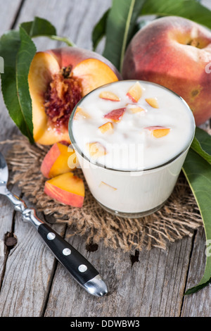 Hausgemachte Pfirsich-Joghurt mit frischen Früchten auf hölzernen Hintergrund Stockfoto