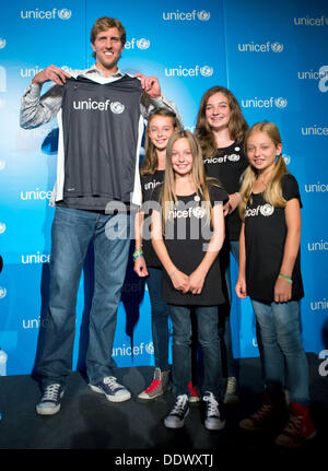 Basketball-Profi Dirk Nowitzki stellt sich mit einem Hemd das UN-Kinderhilfswerk UNICEF präsentiert von Unicef Junior-Botschafter Angelina Limberger (2-L), ihre Schwester Rosalie (C), Alicia Ackermann (2-R) und ihre Schwester Amelie (R) während einer Fotosession in Wörth am Main, Deutschland, 8. September 2013. Die NBA-Star wurde UNICEF-Botschafter ernannt. Foto: FRANK RUMPENHORST Stockfoto