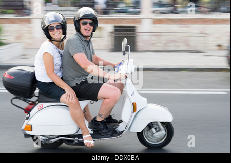 Italienische "Dolce Vita" ein paar Reiten klassisch kultigen Vespa Roller Stockfoto