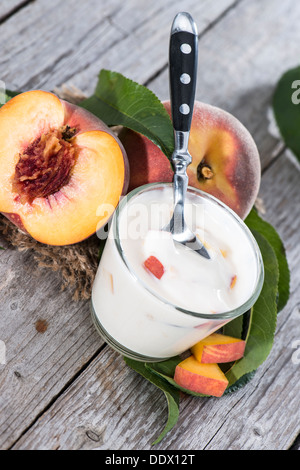 Hausgemachte Pfirsich-Joghurt mit frischen Früchten auf hölzernen Hintergrund Stockfoto