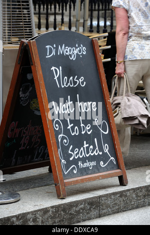 Glasgow City Centre Restaurant Kreidetafel Gönner anfordern, auf "Bitte warten" zu sitzen. Stockfoto