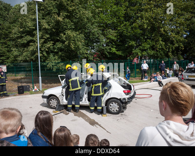 Feuer-Crew zeigt ein Autodach in Rettungs-Simulation am Tag der offenen Tür eine Feuerwache zu schneiden Stockfoto