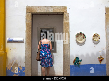 Frau mit Cashpoint, Obidos, Portugal Stockfoto