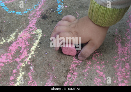 Hand des Kindes hält das Stück Kreide Stockfoto